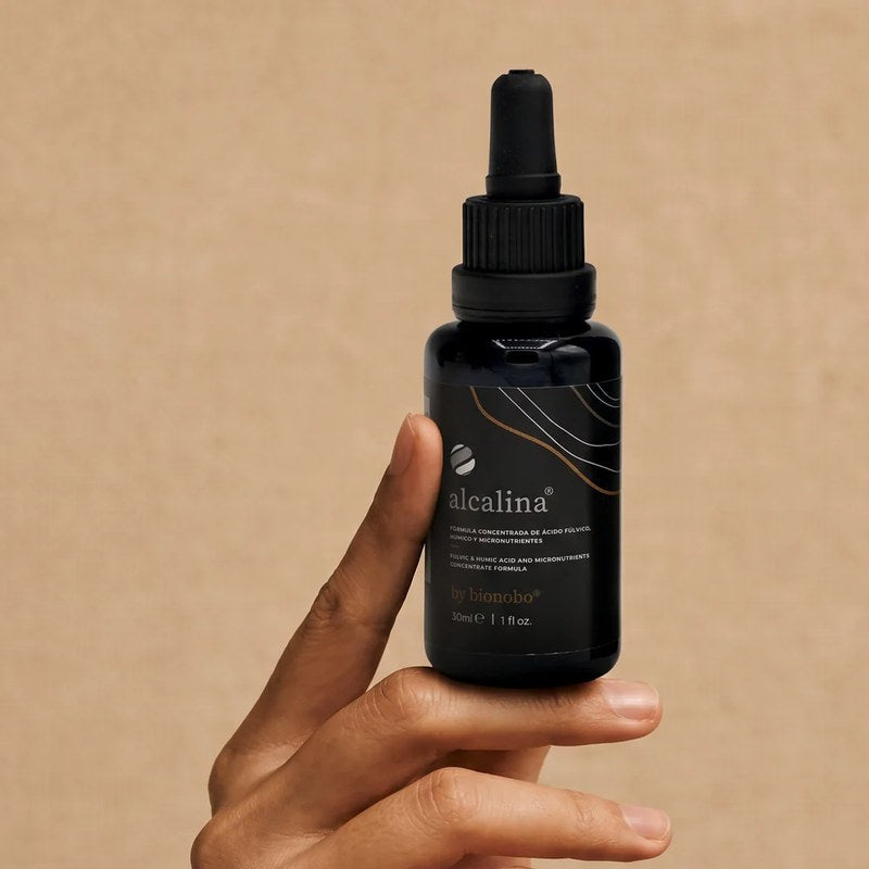 A hand holding the alcalina 30ml dropper bottle